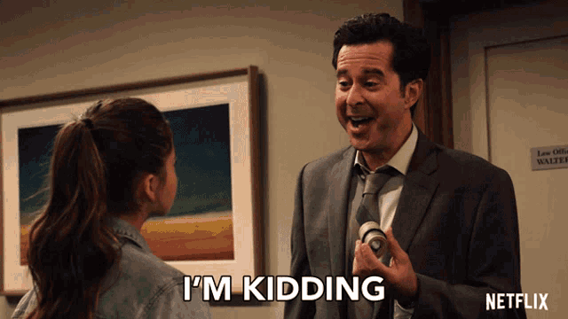 a man in a suit says i 'm kidding in front of a girl