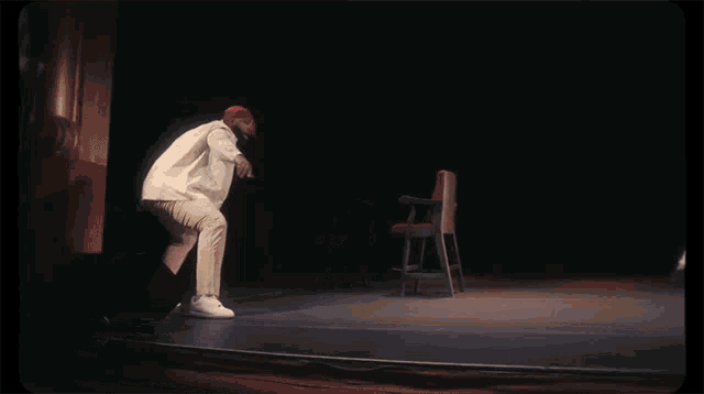 a man in a red hat is dancing on stage