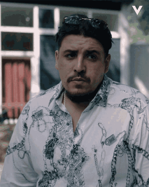 a man wearing a white shirt with chains and the word just on it
