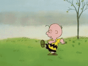 a cartoon character named charlie brown is standing in a field