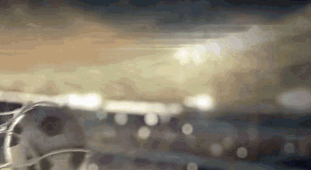 a close up of a soccer ball on a field with a crowd in the background