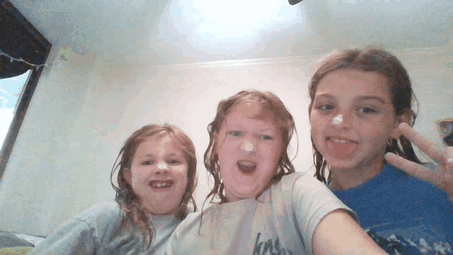 three young girls are posing for a picture with one wearing a shirt that says ' love ' on it