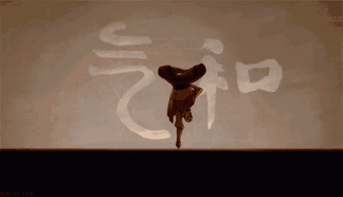 a man is doing a handstand in front of a wall with chinese writing on it
