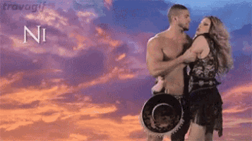 a man and a woman are dancing in front of a cloudy sky and the word ni is on the bottom