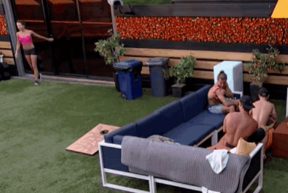 a group of people sitting on a couch with a woman standing behind them