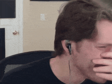 a man wearing ear buds is covering his mouth