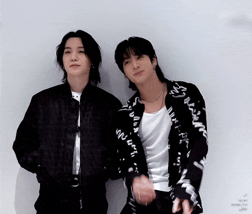 two men are standing next to each other and one of them is wearing a black jacket