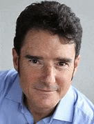a man wearing a blue shirt is smiling for the camera .