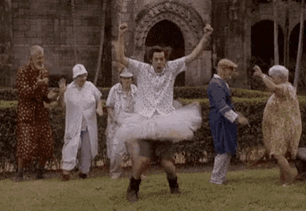 a man in a tutu is dancing in front of a group of elderly people .