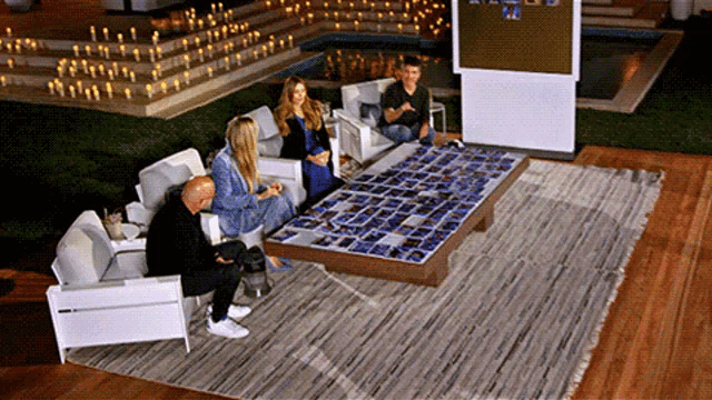 a group of people sitting around a table with pictures on it and a sign that says ' a ' on it