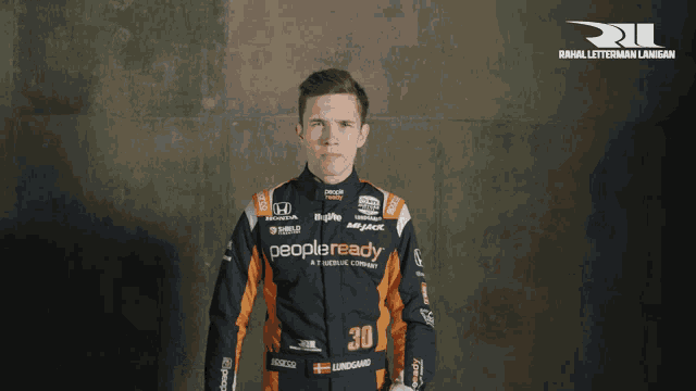 a man in a racing suit with the number 30 on his chest