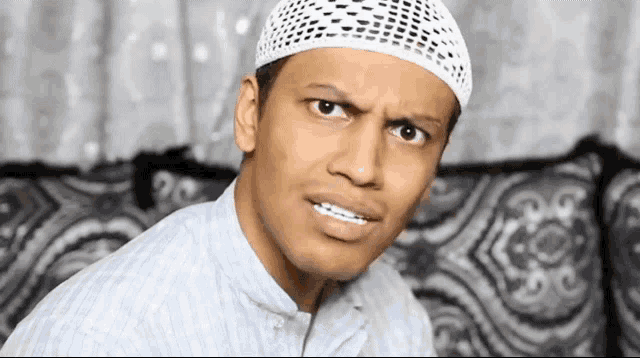 a man wearing a white hat is making a serious face
