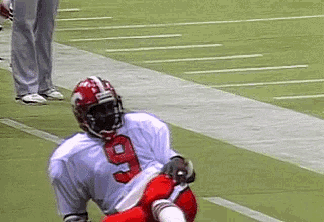 a football player with the number 9 on his jersey is kneeling down on the field .
