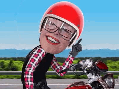 a woman wearing a red helmet and glasses rides a motorcycle
