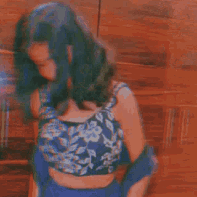 a woman is wearing a blue crop top and blue gloves .