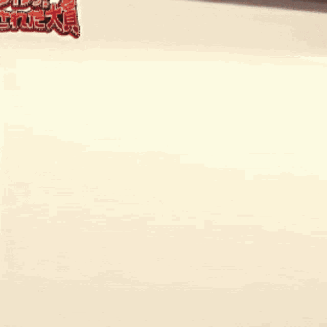 two girls are standing in front of a wall with chinese writing on it .