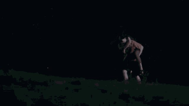 a man is carrying a woman on his shoulders in the dark