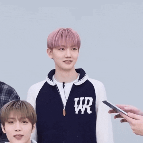 a boy with pink hair is wearing a sweater that says ur on the front