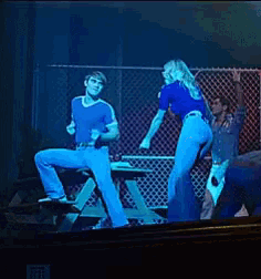 a man is sitting on a bench while a woman is dancing