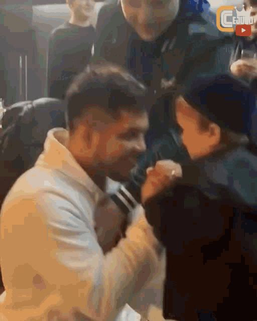 a man holds a child 's hand in front of a sign that says ' ceudo ' on it