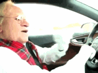 an elderly man wearing glasses and a red scarf is driving a car