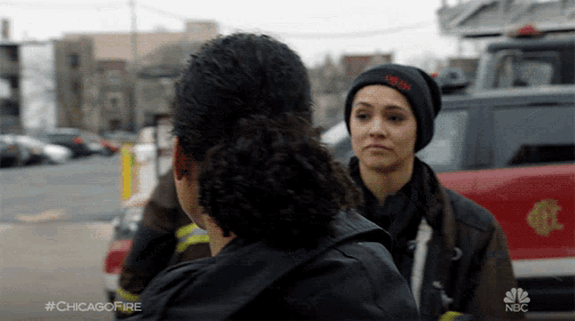 two women standing next to each other in front of a fire truck with the hashtag #chicagofire