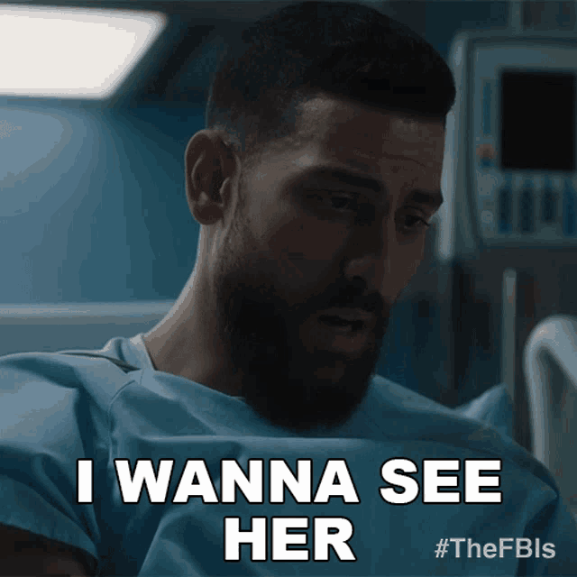 a man with a beard is sitting in a hospital bed and says i wanna see her