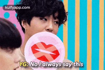 a man is blowing a bubble with a heart on it while holding a lollipop .