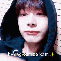 a close up of a person wearing a blue hoodie with the name hyungwon de kam written on it