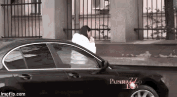 a black car with paparazzi on the side