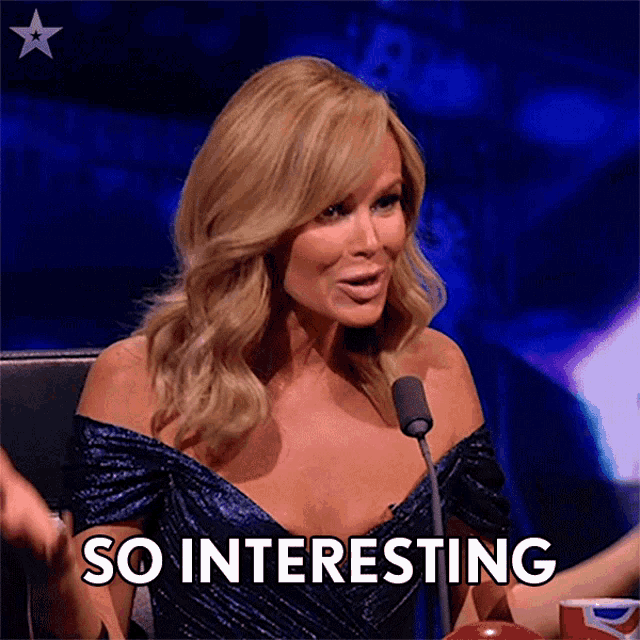 a woman in a blue dress is sitting in front of a microphone and saying so interesting