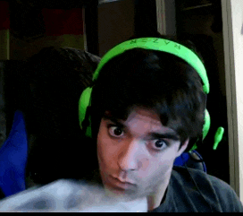 a man wearing green razer headphones is looking at the camera