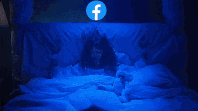 a creepy doll with a facebook logo in front of her