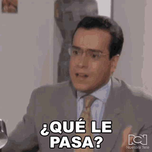 a man in a suit and tie is making a funny face and saying `` que le pasa ? ''