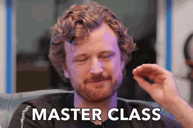 a man with a beard is sitting in a chair with the words master class written on the screen behind him