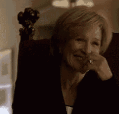 a woman is sitting in a chair with her hand on her face