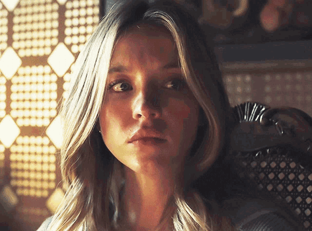 a close up of a woman 's face with a serious look on her face