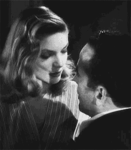 a man and woman are kissing in a black and white photo