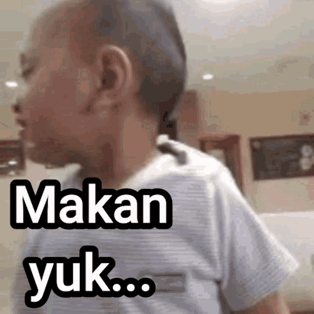 a young boy with a shaved head says makan yuk