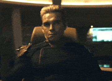 a man in a superhero costume is sitting in a chair