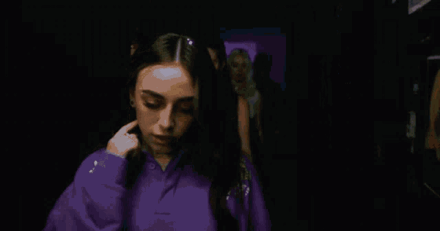 a woman wearing a purple shirt with the word city on the front