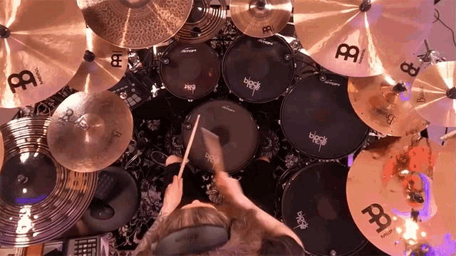 a person is playing a drum set with a cymbal that says ' black ' on it