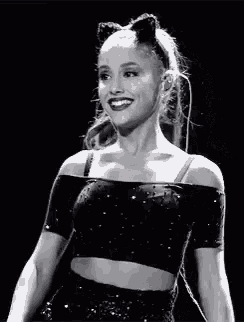 ariana grande is wearing a cat ear headband and a black crop top .
