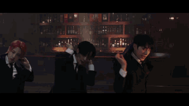 three men in suits are standing in front of a bar holding umbrellas