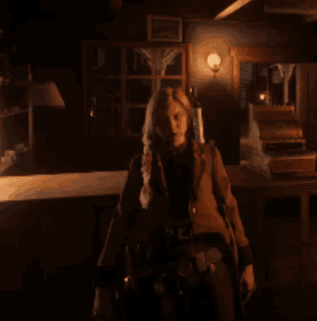 a woman is standing in a dark room with a light on
