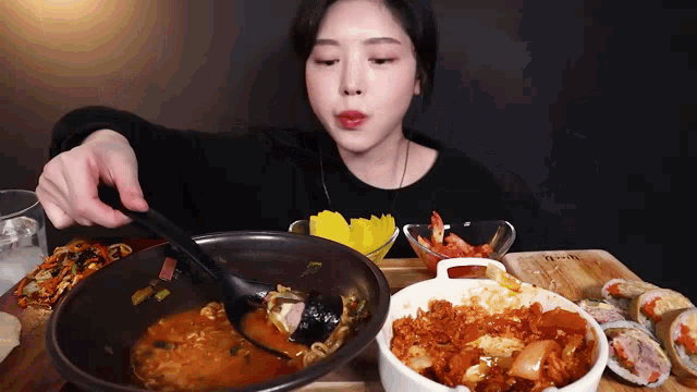 a woman is sitting at a table eating a bowl of food