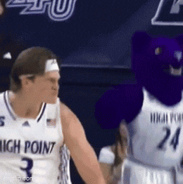 a basketball player with the number 3 on his jersey stands next to a mascot