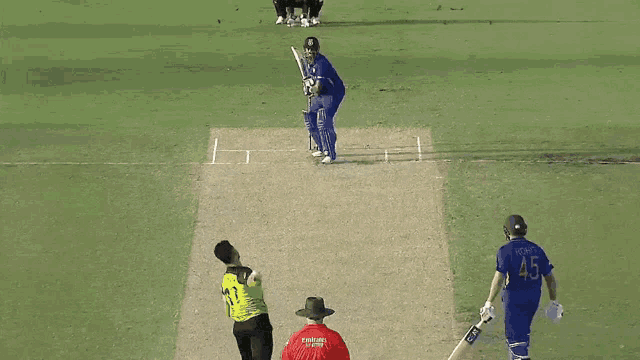 a cricket player with the number 45 on his back is about to hit the ball