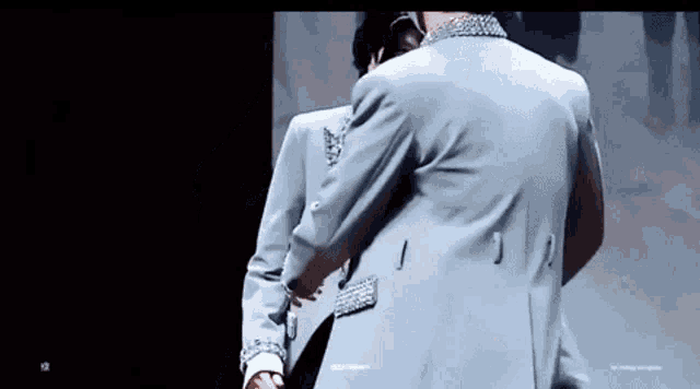 a couple of men are standing next to each other holding hands .
