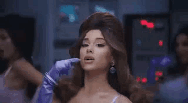 ariana grande is wearing a wig and purple gloves in a video for her new song .